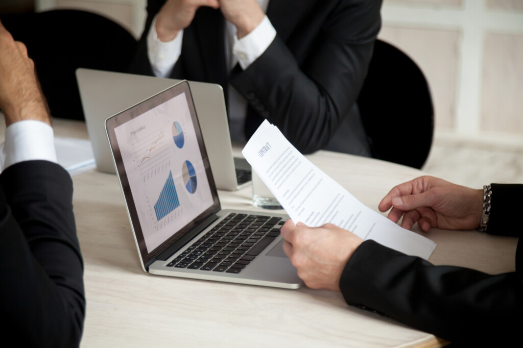 Hommes d'affaires analysant des contrats et l'état d'une société avec notaire