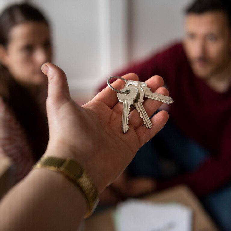 Plusieurs personnes récupérant les clés de leur logement suite à une acquisition en indivision chez le notaire