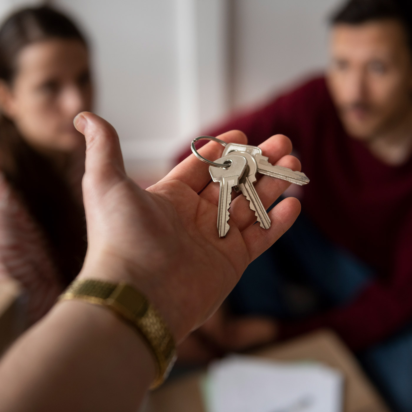 Plusieurs personnes récupérant les clés de leur logement suite à une acquisition en indivision chez le notaire