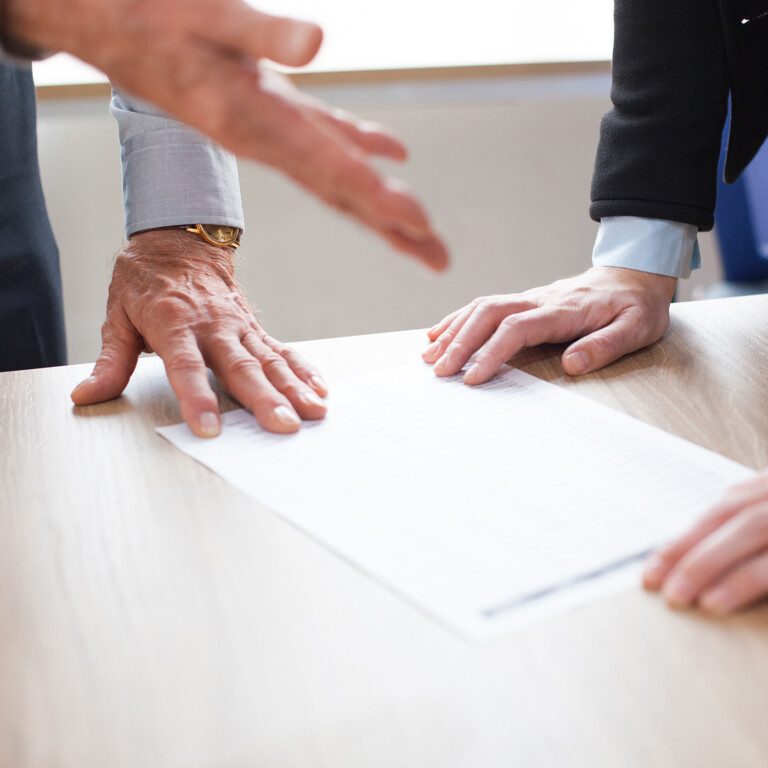 2 personnes concluant un accord pour la transmission d'une entreprise via le Pacte Dutreil.